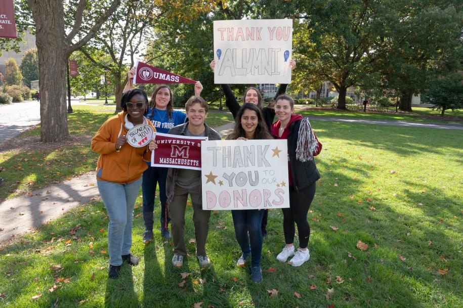 Group of students showing their UMass pride and holding thank you signs